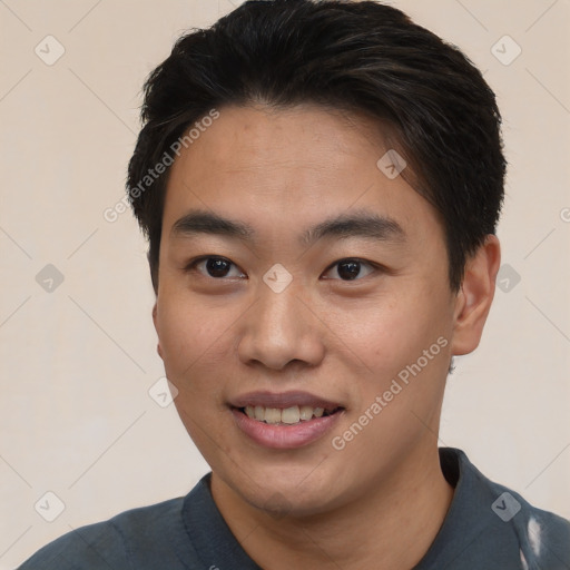 Joyful asian young-adult male with short  black hair and brown eyes