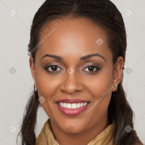 Joyful black young-adult female with long  brown hair and brown eyes