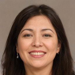 Joyful white adult female with long  brown hair and brown eyes