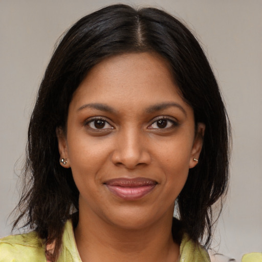 Joyful black young-adult female with medium  brown hair and brown eyes