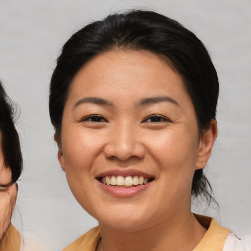 Joyful asian young-adult female with medium  brown hair and brown eyes
