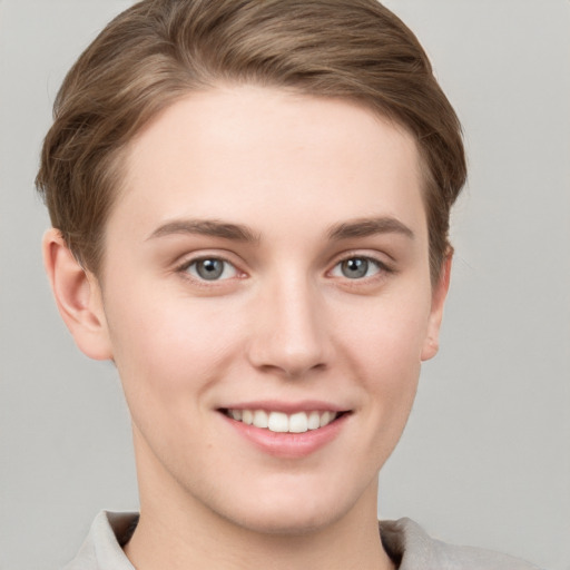 Joyful white young-adult female with short  brown hair and grey eyes