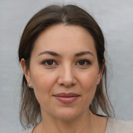 Joyful white adult female with medium  brown hair and brown eyes