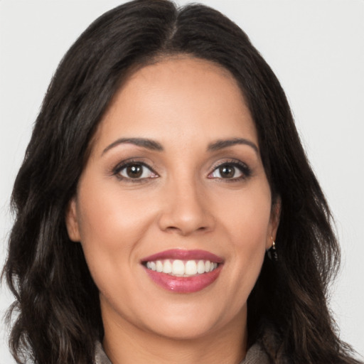 Joyful latino young-adult female with long  brown hair and brown eyes