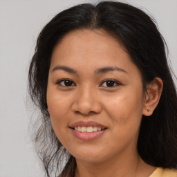 Joyful latino young-adult female with long  brown hair and brown eyes