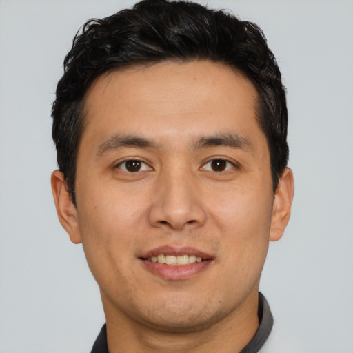Joyful asian young-adult male with short  brown hair and brown eyes