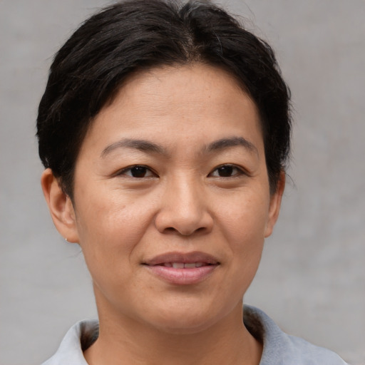 Joyful asian adult female with short  brown hair and brown eyes