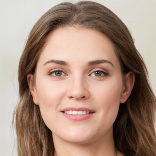 Joyful white young-adult female with long  brown hair and green eyes