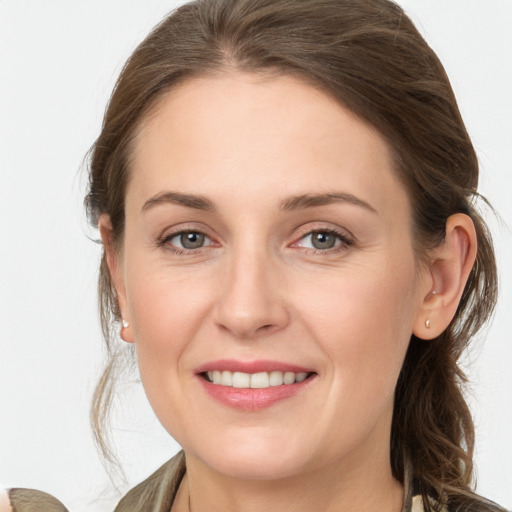 Joyful white young-adult female with medium  brown hair and grey eyes