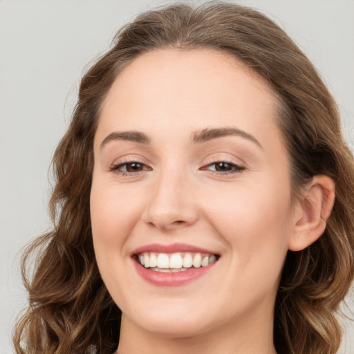 Joyful white young-adult female with long  brown hair and blue eyes