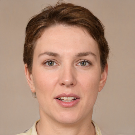 Joyful white young-adult female with short  brown hair and grey eyes