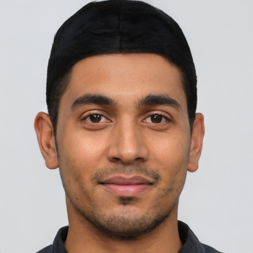 Joyful latino young-adult male with short  black hair and brown eyes