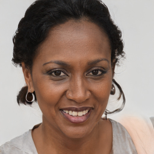 Joyful black adult female with medium  brown hair and brown eyes