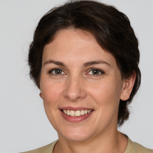 Joyful white young-adult female with medium  brown hair and green eyes