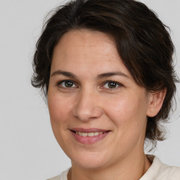 Joyful white adult female with medium  brown hair and brown eyes