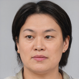 Joyful asian adult female with medium  brown hair and brown eyes