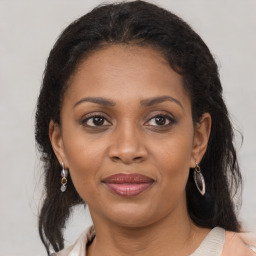 Joyful black adult female with medium  brown hair and brown eyes