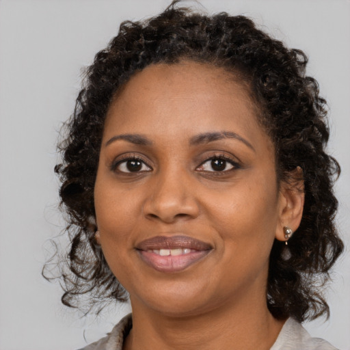 Joyful black young-adult female with medium  brown hair and brown eyes