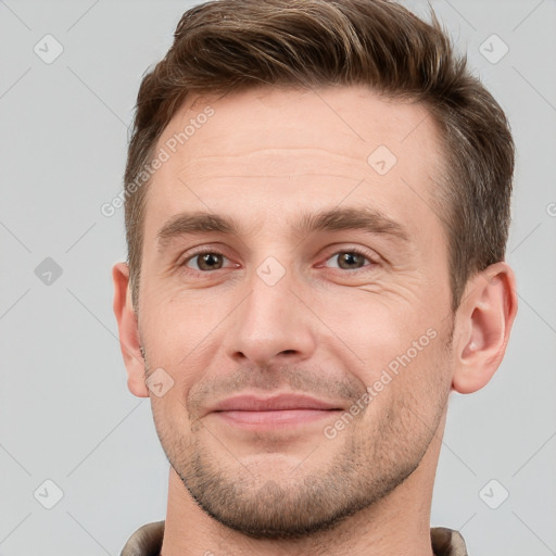 Joyful white young-adult male with short  brown hair and grey eyes