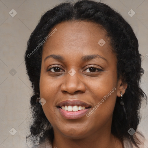 Joyful black young-adult female with long  black hair and brown eyes