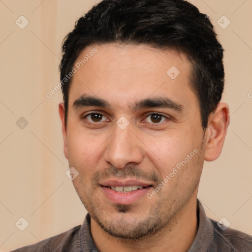 Joyful white young-adult male with short  black hair and brown eyes