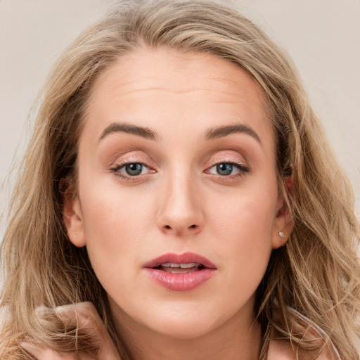 Joyful white young-adult female with long  brown hair and blue eyes