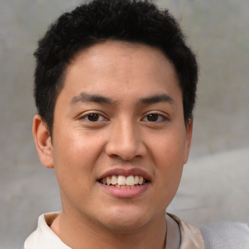 Joyful latino young-adult male with short  brown hair and brown eyes