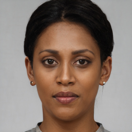 Joyful black young-adult female with short  black hair and brown eyes