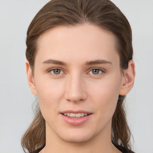 Joyful white young-adult female with long  brown hair and grey eyes