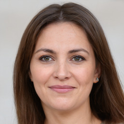 Joyful white adult female with long  brown hair and brown eyes