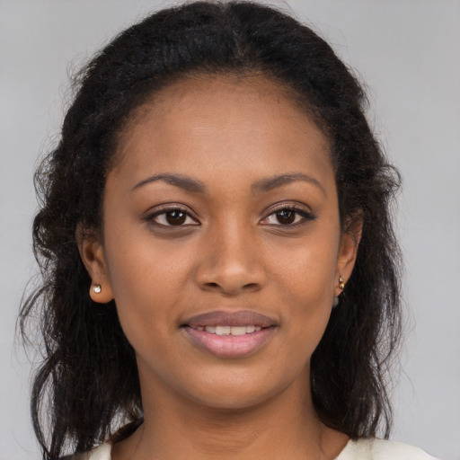 Joyful black young-adult female with long  brown hair and brown eyes