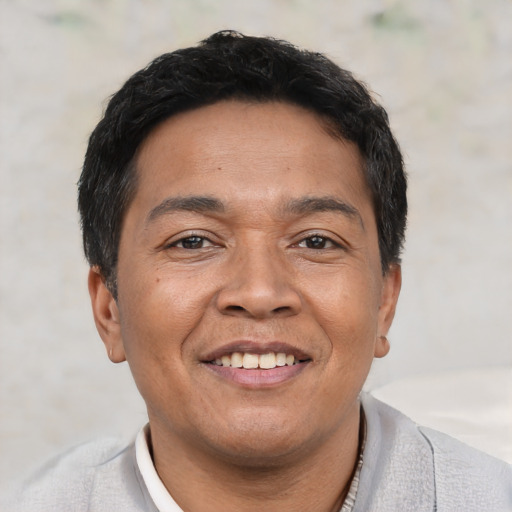 Joyful asian adult male with short  black hair and brown eyes