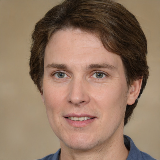 Joyful white adult male with medium  brown hair and brown eyes