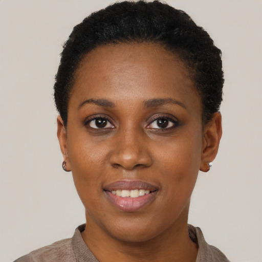 Joyful black young-adult female with short  black hair and brown eyes