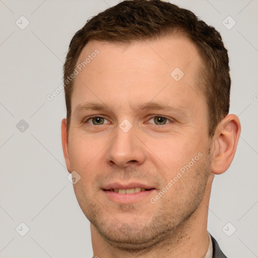 Joyful white young-adult male with short  brown hair and grey eyes