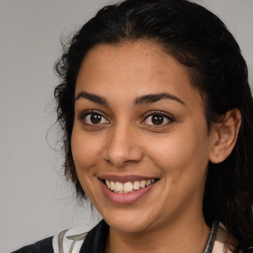 Joyful latino young-adult female with medium  brown hair and brown eyes