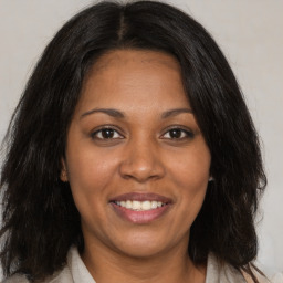 Joyful black adult female with medium  brown hair and brown eyes