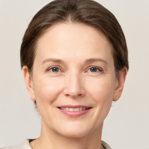 Joyful white adult female with short  brown hair and grey eyes