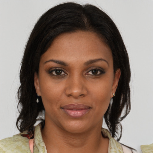 Joyful black young-adult female with medium  brown hair and brown eyes