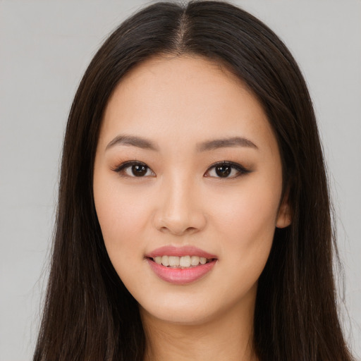 Joyful asian young-adult female with long  brown hair and brown eyes