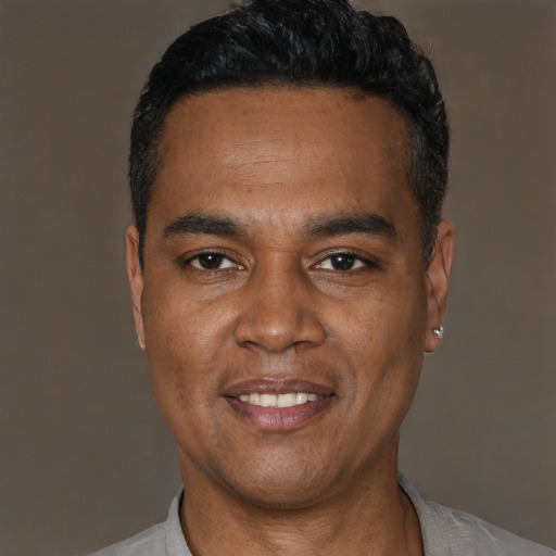 Joyful black young-adult male with short  black hair and brown eyes