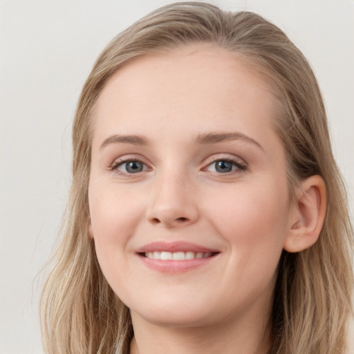 Joyful white young-adult female with long  brown hair and blue eyes