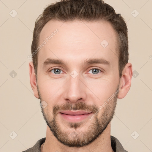 Joyful white young-adult male with short  brown hair and grey eyes