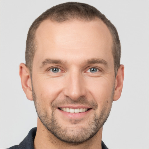 Joyful white young-adult male with short  brown hair and grey eyes