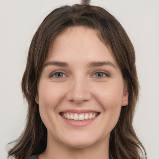 Joyful white young-adult female with long  brown hair and green eyes