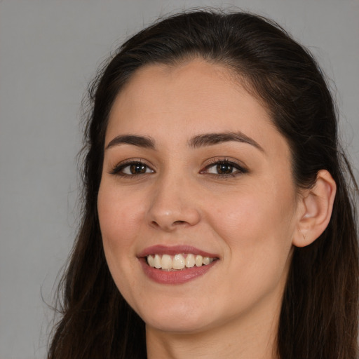 Joyful white young-adult female with long  brown hair and brown eyes