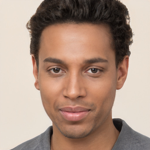 Joyful black young-adult male with short  brown hair and brown eyes