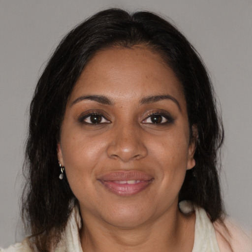 Joyful black adult female with medium  brown hair and brown eyes