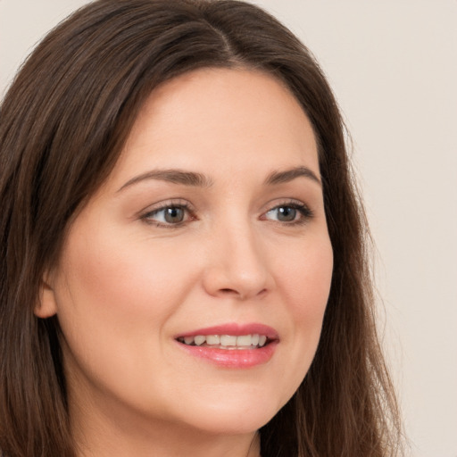 Joyful white young-adult female with long  brown hair and brown eyes