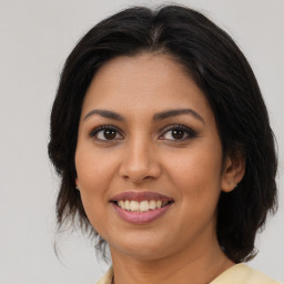 Joyful latino young-adult female with medium  brown hair and brown eyes